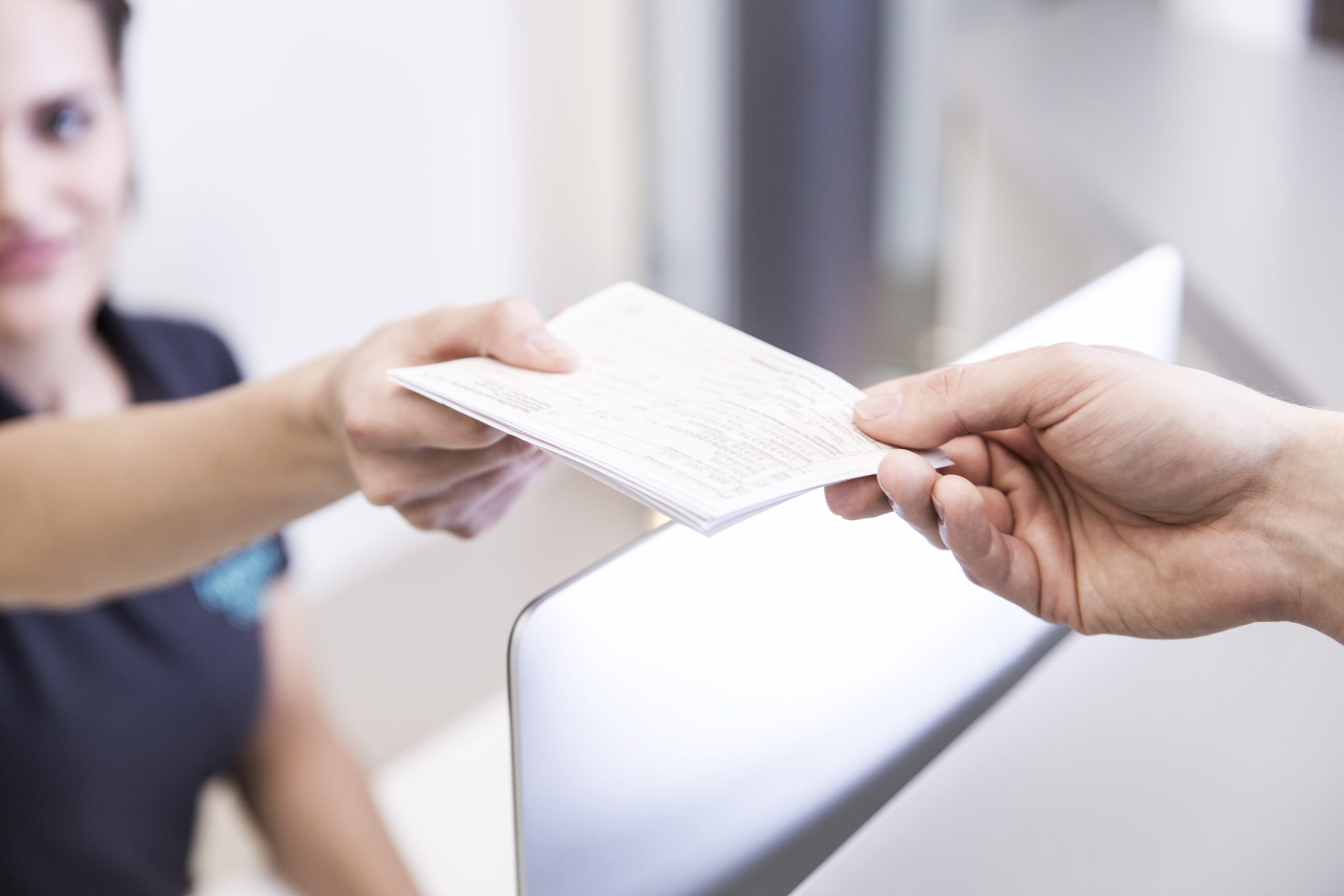 Receptionist handing prescription to patient